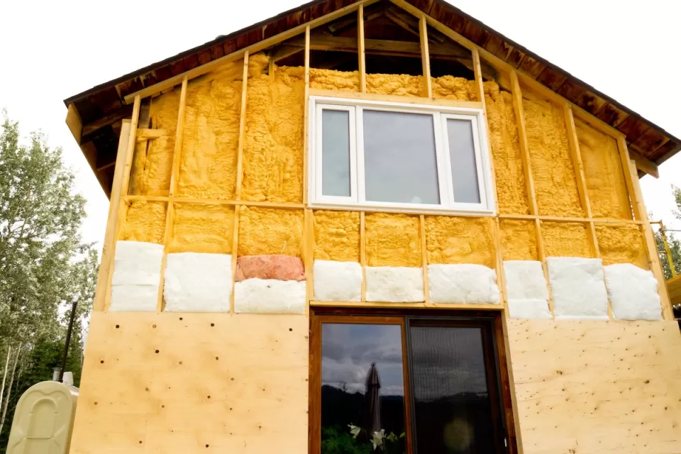 Two-story home being retrofitted with energy-saving insulation.